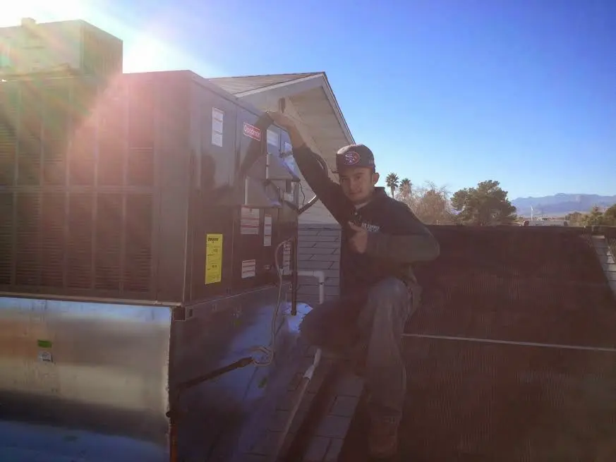 HVAC technician performing AC Tune-Up on a rooftop unit in Hermantown